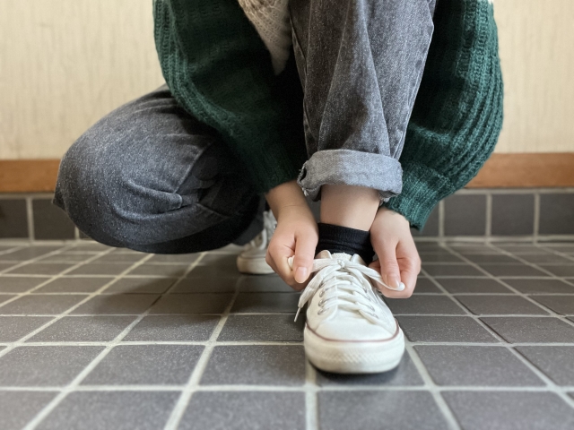 靴紐を結んでいる女性